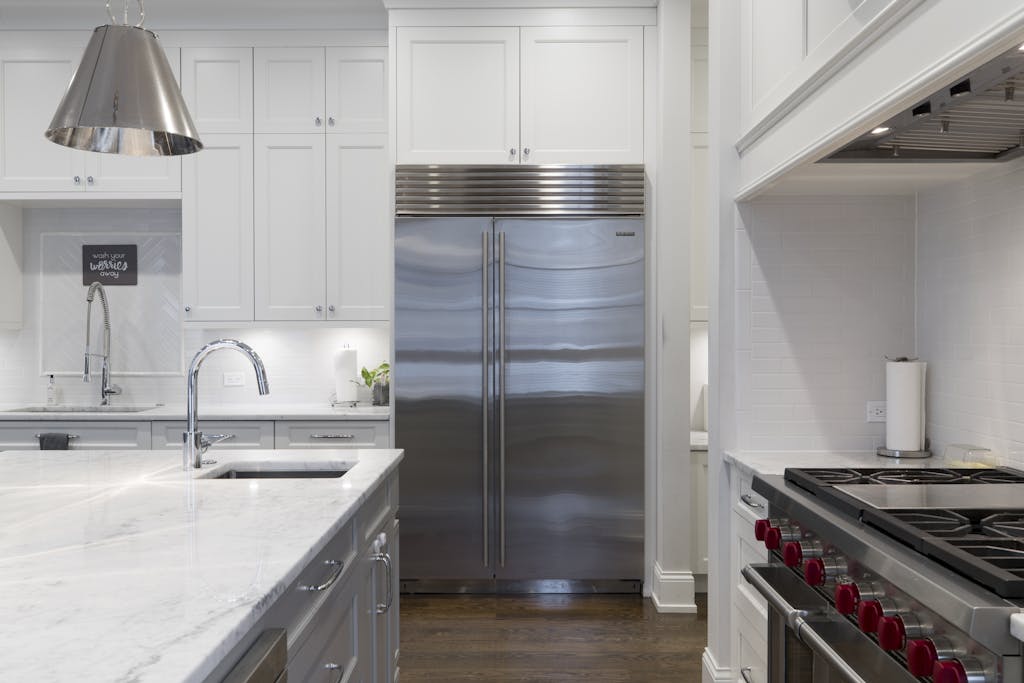 A sleek modern kitchen featuring stainless steel appliances and marble countertops.