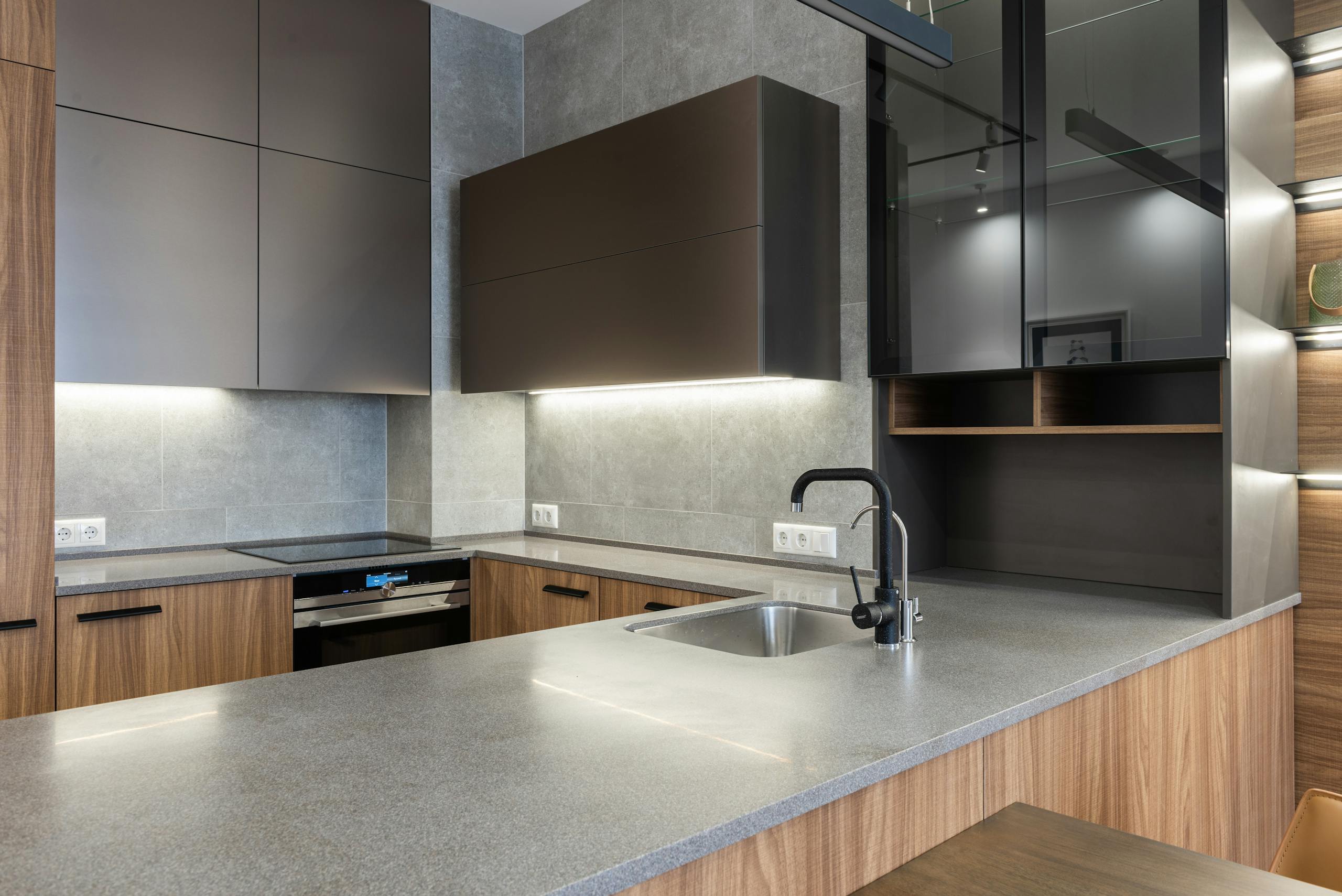 Contemporary kitchen with wooden cabinetry and stainless steel appliances, showcasing elegant design.