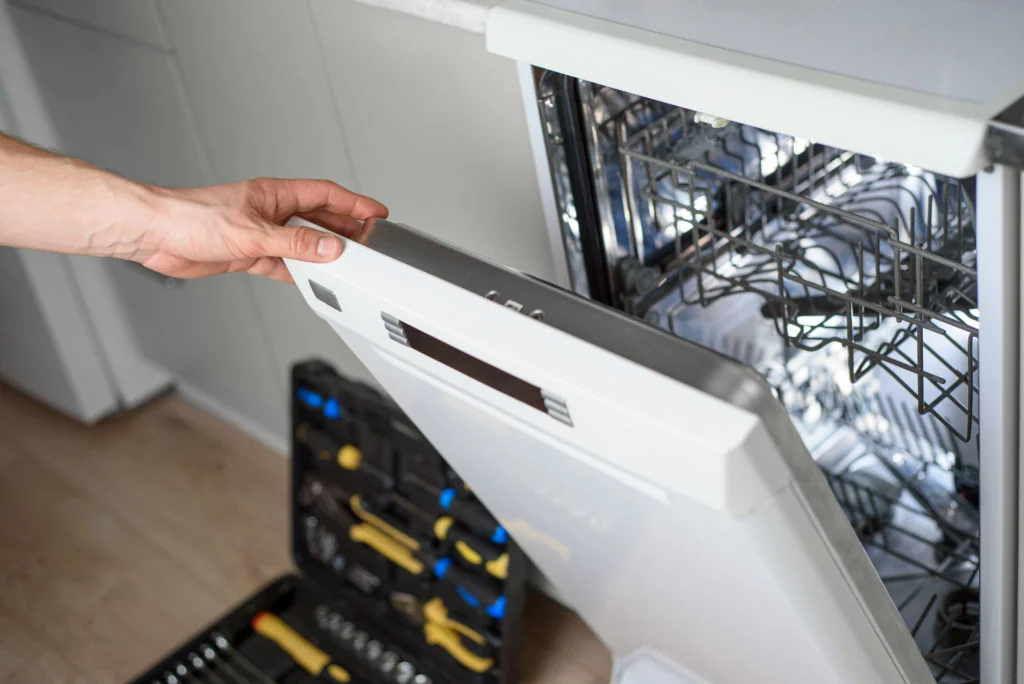 Dishwasher repair technician opening a dishwasher in Leander, TX