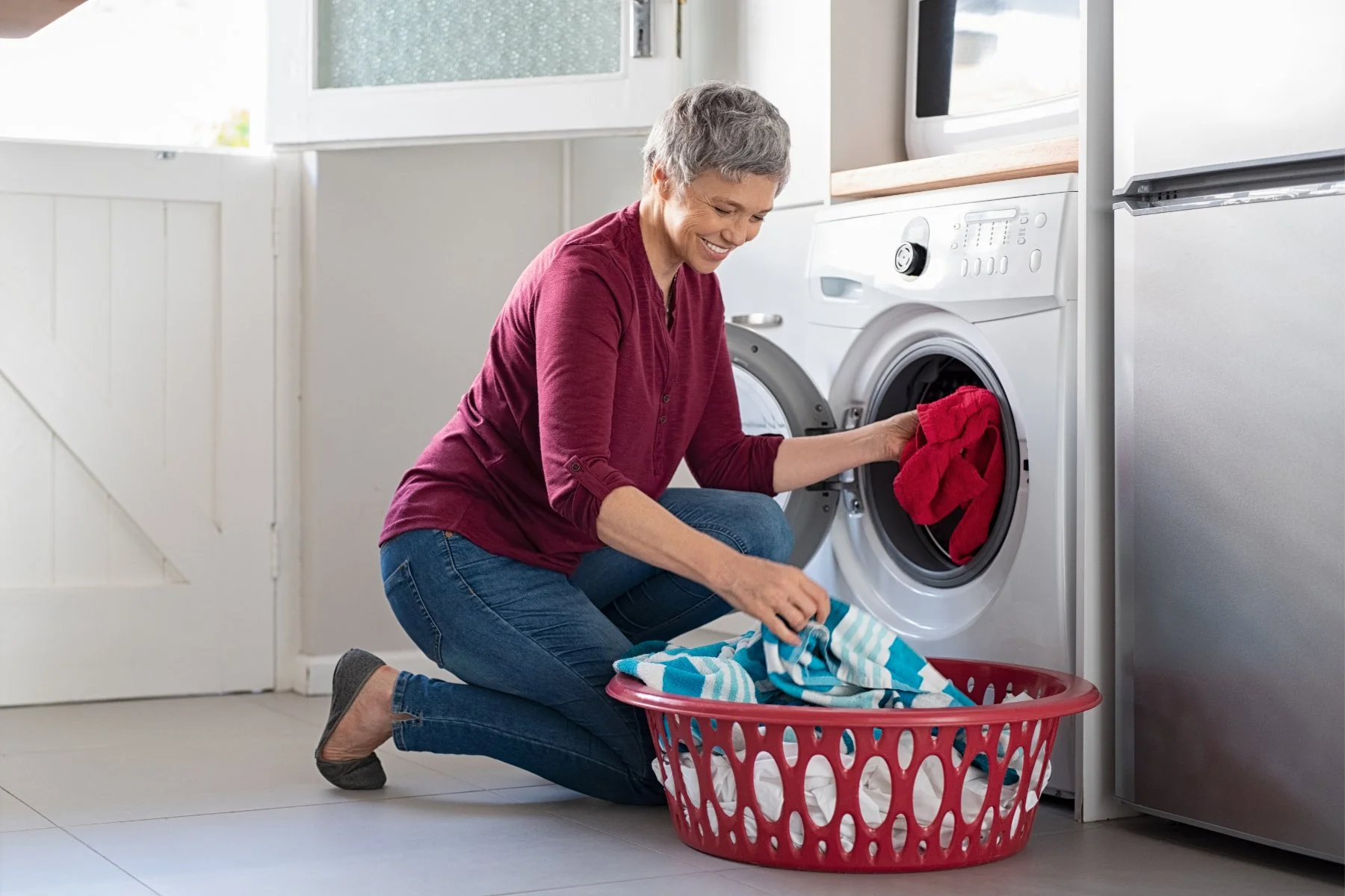 Happy woman loading fresh laundry after dryer repair in Leander, TX