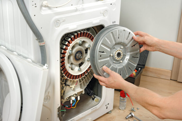 repairman replacing a cylinder on a dryer