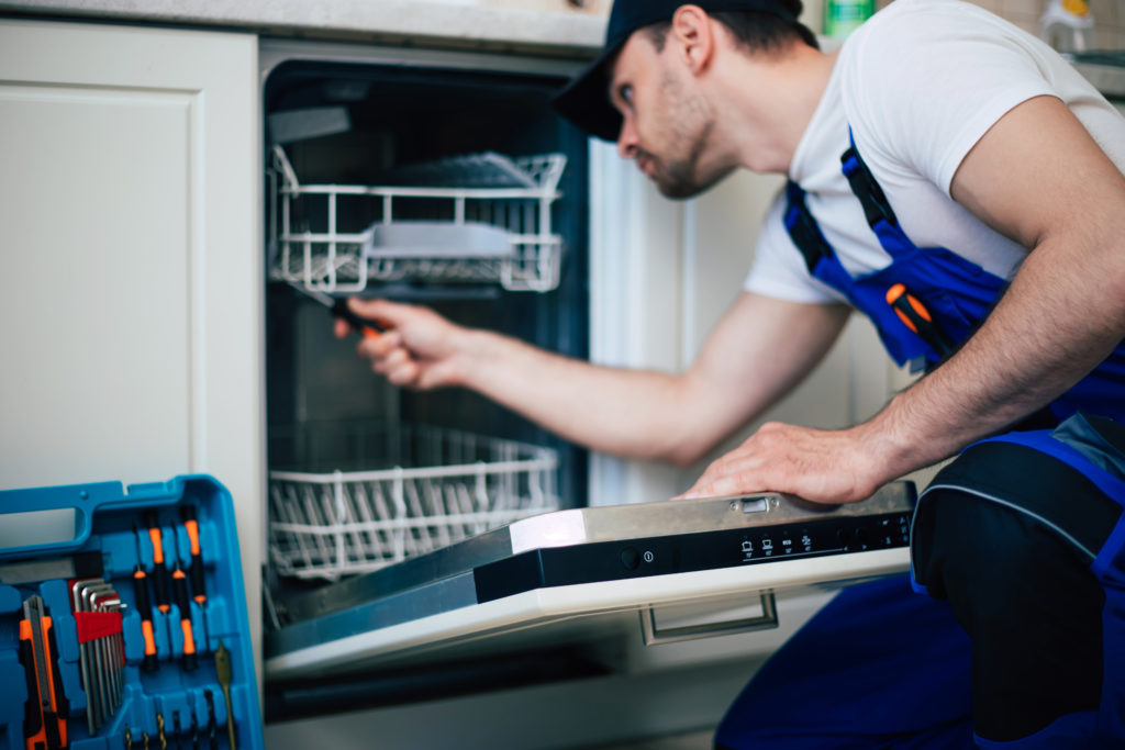 repairman fixing a dishwasher